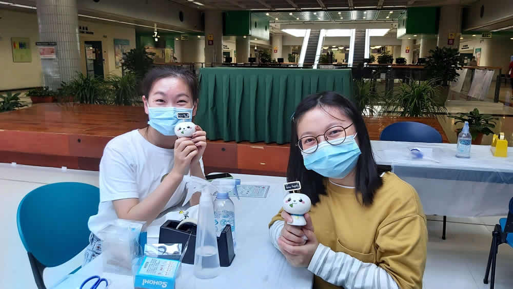 Students taking photos with Caring Leaders and Mindful Self-Compassion tote bags.